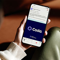 Holding a phone showing the Coda app